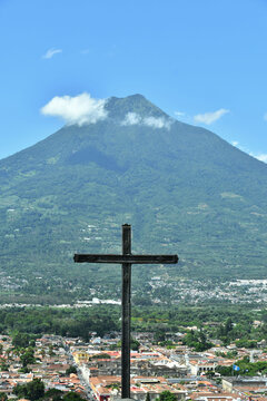 Cruz apuntado hacia la ciudad de Antigua Guatemala, al fondo el volc&aacute;n de agua. Destino tur&iacute;stico en Guatemala. Toma Vertical.