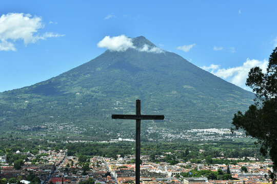 Cruz apuntado hacia la ciudad de Antigua Guatemala, al fondo el volc&aacute;n de agua. Destino tur&iacute;stico en Guatemala. Toma Horizontal.