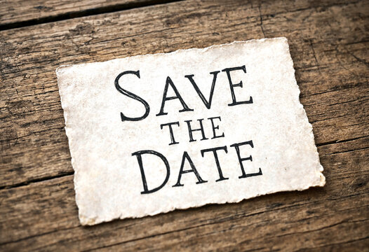 Vintage torn paper with save the date text on rustic wooden background perfect for invitations