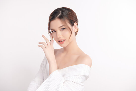 A beautiful young Asian woman with clean, fresh skin against a white background. Skincare, facial treatment, cosmetology, beauty, and spa. An elegant portrait of an Asian woman.