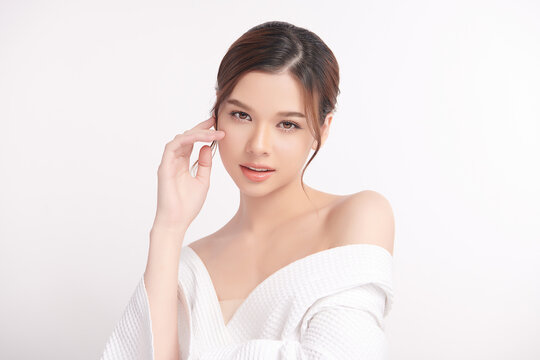 A beautiful young Asian woman with clean, fresh skin against a white background. Skincare, facial treatment, cosmetology, beauty, and spa. An elegant portrait of an Asian woman.