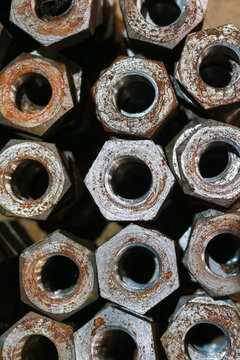 Stack of rusted industrial metal hex nuts, Close up shot of heavy duty rusty steel hardware, Steel fasteners background