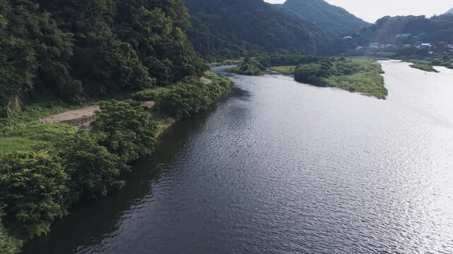 山間を流れる川と緑豊かな森林の空撮