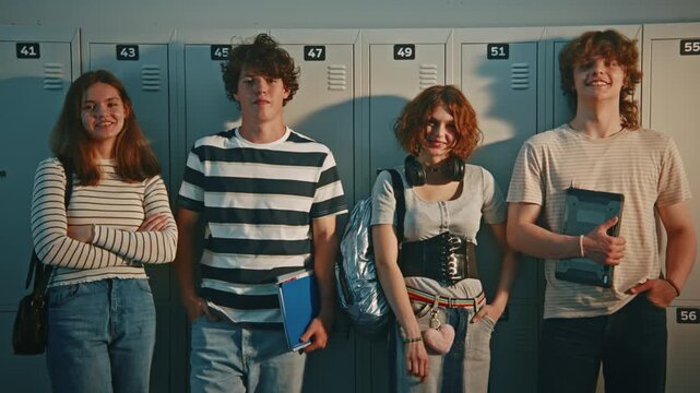 Teenage Standing Against School Lockers, Sharing Laugh and Talking, Wearing Casual Trendy Clothes and Holding School Supplies. School Life Socialization, Modern Youth Lifestyle on Campus. Portrait.