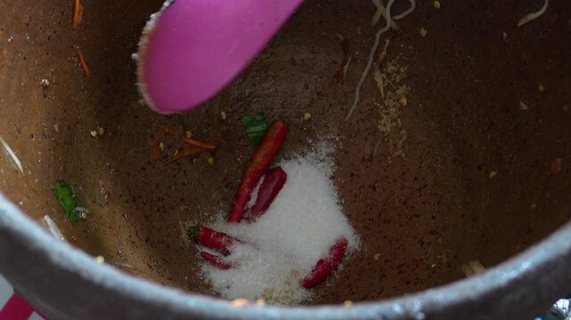 4K High angle close-up shot of red chilies and monosodium glutamate powder inside clay mortar for making Thai papaya salad, Cooking process Thai food spicy dish and street food.