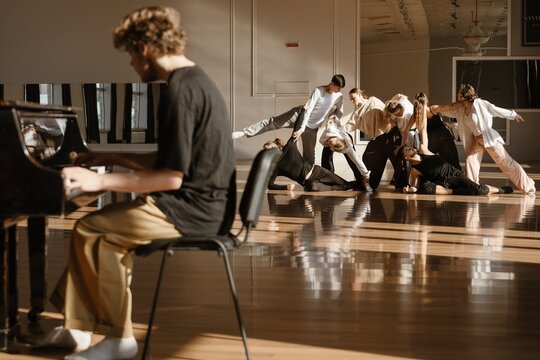 Group of dancers playing piano in a contemporary dance studio