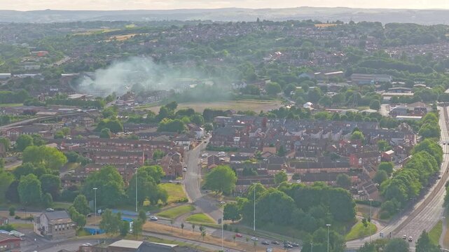 Rotherham city centre, South Yorkshire, England, United Kingdom, revealing residential neighborhoods, urban road network and morning haze above the town during a drone ascent.