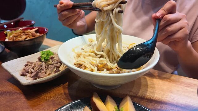 Person Lifting Spicy Taiwanese Hot and Sour Noodles with Chopsticks