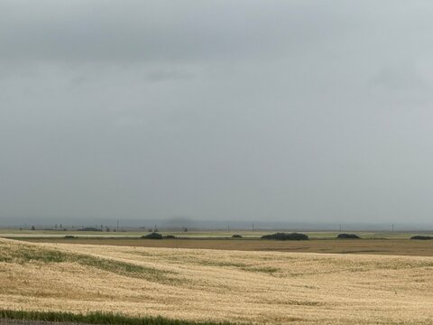 Storm Over an Open Farm Field With Dark Cloud Formations, Expansive Agricultural Landscape and Rural Prairie Scenery