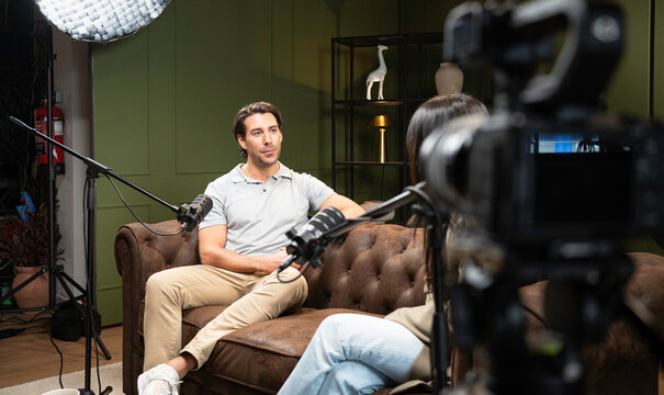 Man talking while recording a podcast or interview with a guest in a professional studio setup