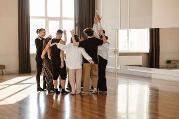 Group of dancers raising hands in a contemporary dance studio © Drobot Dean