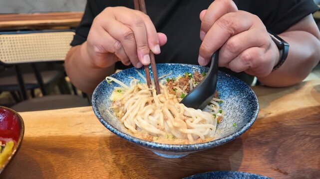 Person Mixing Taiwanese Sesame Noodles with Minced Pork and Green Onions