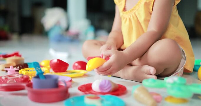 Little Girl Playing with Toy Kitchenware, Child playing with colorful pretend kitchen and food toys. Creative play encourages imagination, learning, motor skills, early childhood development
