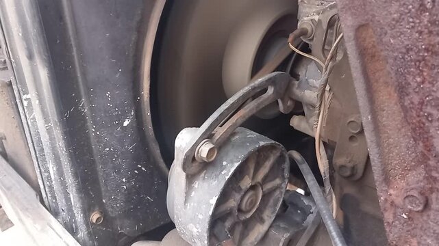Close up of a tractor cooling fan and belt whirring during engine revs in action