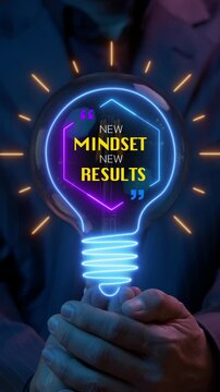 Businessman open hands vertical shot supporting glowing lightbulb displaying NEW MINDSET NEW RESULTS text inside. Growth mindset transformation, creative innovation, and success change concept.