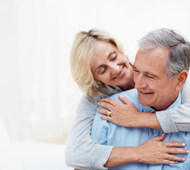 Fototapeta premium Hug, smile and space with old couple in home for bonding, romantic connection and marriage. Retirement, trust and support with senior man and woman in living room in apartment for love and care