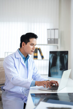 Doctor working on laptop in medical office.