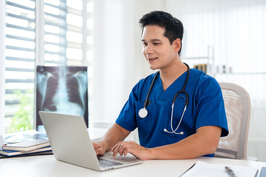 Doctor working in office, using a laptop to access patient records on system. Mature physician using modern technology in her practice.