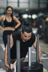 Fototapeta premium Strong Asia man doing prowler sled workout