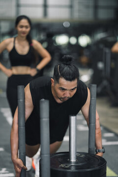 Strong Asia man doing prowler sled workout