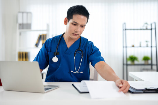 Doctor looking at laptop screen writing in notebook for research planning or medical tech innovation in hospital office. Healthcare medic worker, research strategy book notes and online communication.