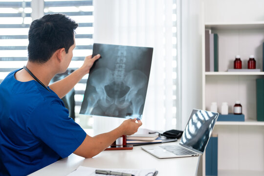 Doctor radiology  holding x-ray film , reviewing patient diagnosis results in clinic.