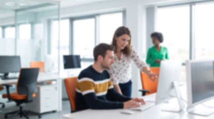 Fototapeta premium Professional colleagues working together in bright modern office space with computer monitors and orange chairs blurred for creative background copy space and business focus