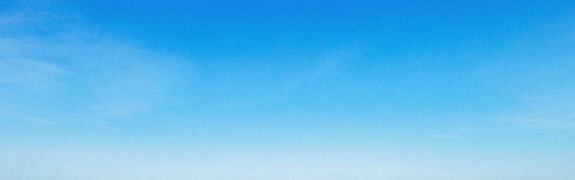 Clear blue sky with soft wisps of clouds