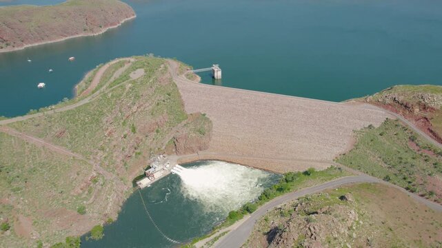 Aerial View Of A Dam Wall With Water Discharge And Boats On The Reservoir Near Kununurra, Drone Shot