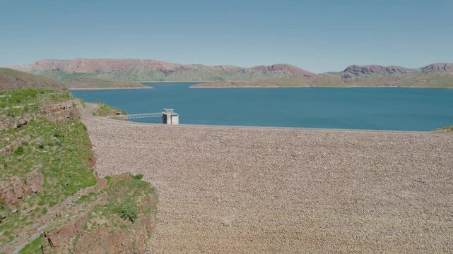 View Of A Large Reservoir And Dam Wall In Kununurra at Argyle Lake Surrounded By Rocky Ridges Under Clear Sky, Static Shot