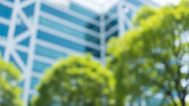 Out of focus modern office building with green trees