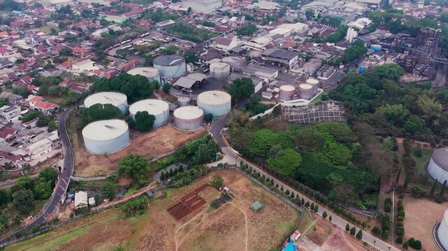 Aerial drone view of an industrial fuel storage terminal in Indonesia, featuring large storage tanks, pipelines, loading facilities, and supporting infrastructure for petroleum products and energy dis