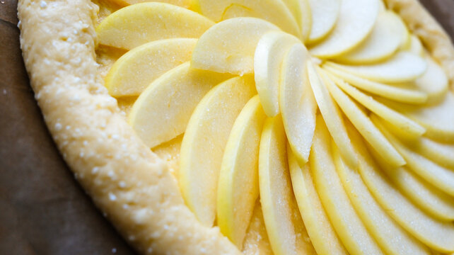 A delightful apple dessert. A pie made from raw apples in the process of being prepared.