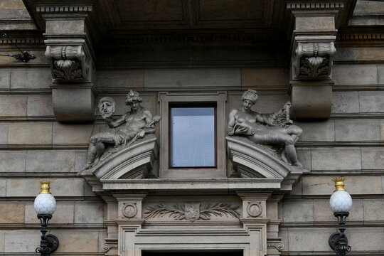 Ornate window with decorative stone brackets and lamp posts on a building facade, Prague, Czech Republic