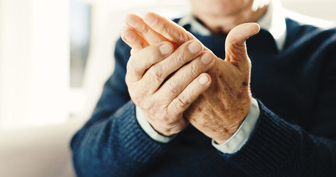 Senior, man and hands with wrist injury in retirement home for carpal tunnel syndrome or arthritis. Elderly, male person or arm pain with joint inflammation or discomfort for fibromyalgia in house