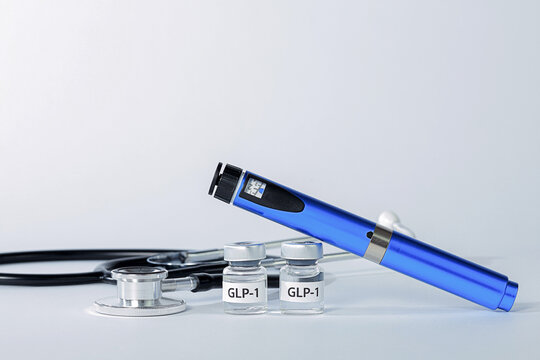 Hopeful professional medical weight management concept features blue injection pen with stethoscope and vial for obesity treatment