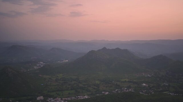 Aerial view of Aravalli mountain range in India at sunset with hazy sky and valley landscape