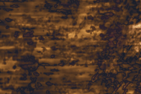 Semi-blurred rust dark golden brown abstract grunge background. Organic mottled patterns reminiscent of weathered parchment, oxidized metal, or aged vintage leather
