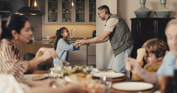 Big family, dinner and father with girl for dance, bonding and playful together in home. Holding hands, smile and dad with daughter for fun and support with love, music and help with development