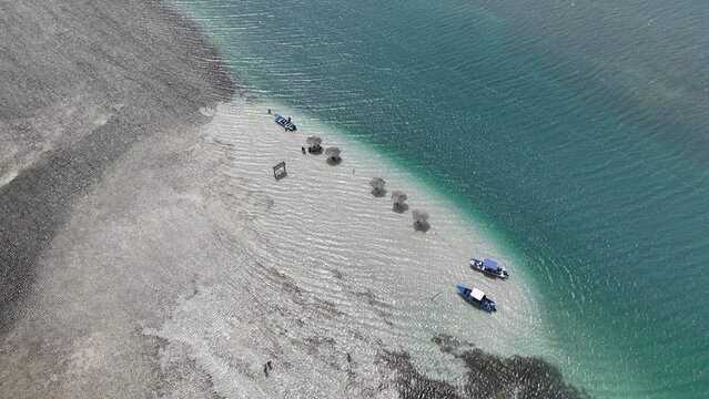 Aerial view of Banco de arenas Grand Grossier with small boats and straw umbrellas on a white sandbar surrounded by turquoise water in Monte Cristi, Monte Cristi, Dominican Republic.