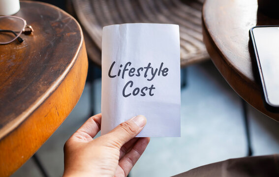 Hand Holding Paper Note Displaying Lifestyle Cost Text