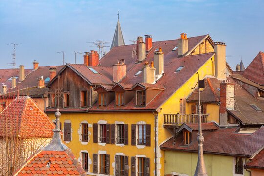 Colorful historic houses with red tiled roofs and chimneys in the old center of Annecy, France.