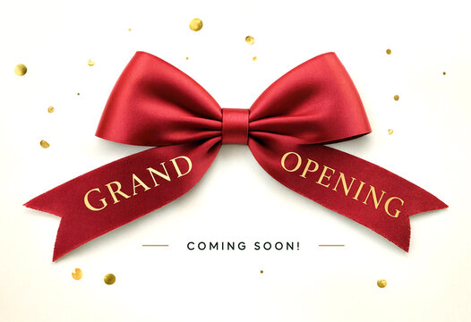 Beautiful red satin ribbon bow with grand opening text and confetti for celebration event announcement