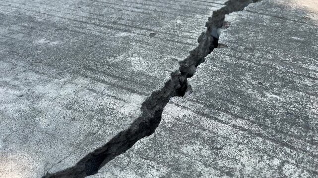 Deep crack on concrete road surface earthquake damage concept