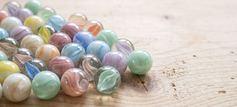 Collection of pastel glass marbles on a wooden table