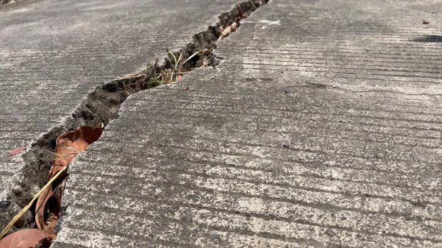 Deep crack fracture on concrete road surface close up