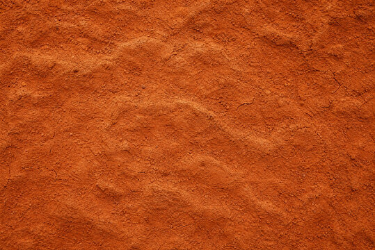 Red desert sand texture, aerial view of orange soil ripples, natural dry earth background for environmental design