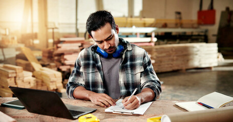 Naklejka premium Man, writing and clipboard at workshop for carpentry, stock and timber price for production. Carpenter, laptop and checklist at factory for compliance, quotation and order for manufacturing furniture