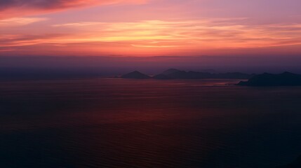 Obraz premium Serene sunset ocean view silhouetted islands peaceful sky vibrant colors tranquil atmosphere landscape photography