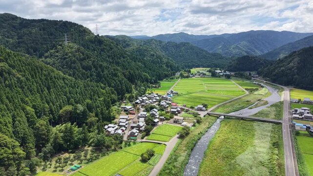 ドローンで撮る日本の風景　川沿いに広がる静かな集落と美しい田園風景　ゆっくり前進しながら下降する空撮
